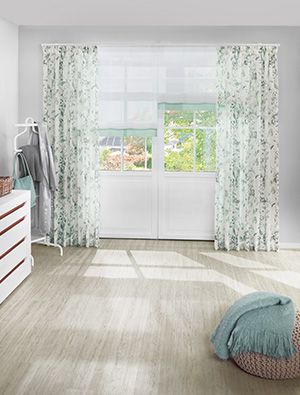 Heller Wohnraum mit floralen Vorhängen in Grün-Weiß aus der Kollektion Lebendige Vielfalt