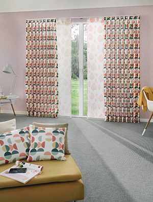 Gemütlicher Wohnraum mit pastellfarbenen Vorhängen im grafischen Design aus der Kollektion Nordischer Flair