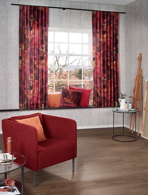 Wohnraum mit kräftigen roten Vorhängen und modernem Sessel aus der Kollektion Weltoffene Akzente