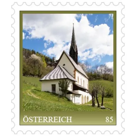 4b809a4fac3b539196005aa2ebdb4f06f95fc31d.jpg Briefmarke Österreich 2023, Nominale 0,85 Euro: Kirche in ländlicher Landschaft unter blauem Himmel.