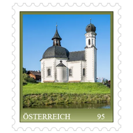 Briefmarke Österreich 2023, Nominale 0,95 Euro: Kirche in grüner Landschaft mit blauem Himmel.
